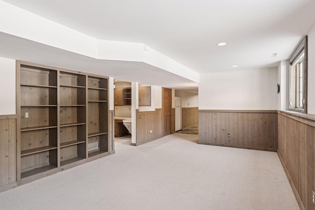 unfurnished room featuring recessed lighting, a wainscoted wall, light colored carpet, and wood walls