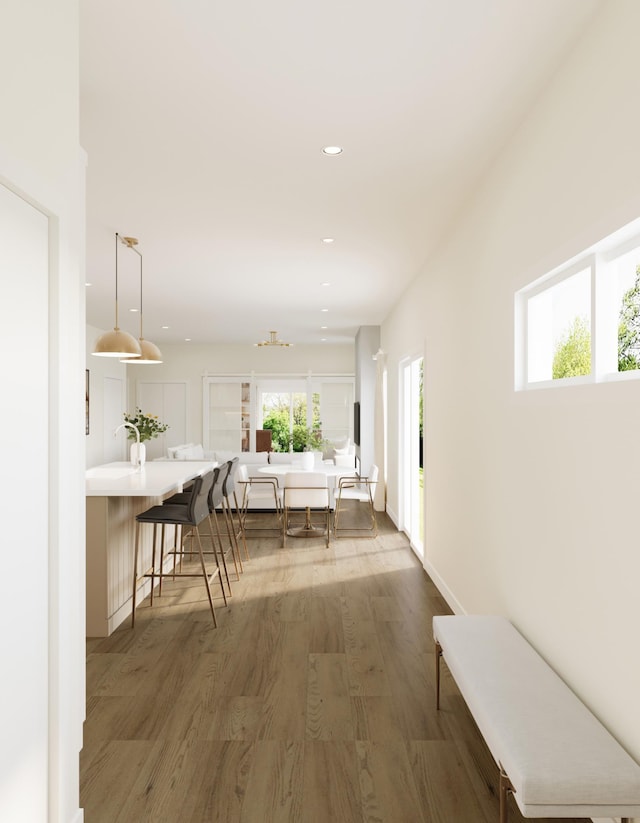 hallway with recessed lighting, a healthy amount of sunlight, and wood finished floors