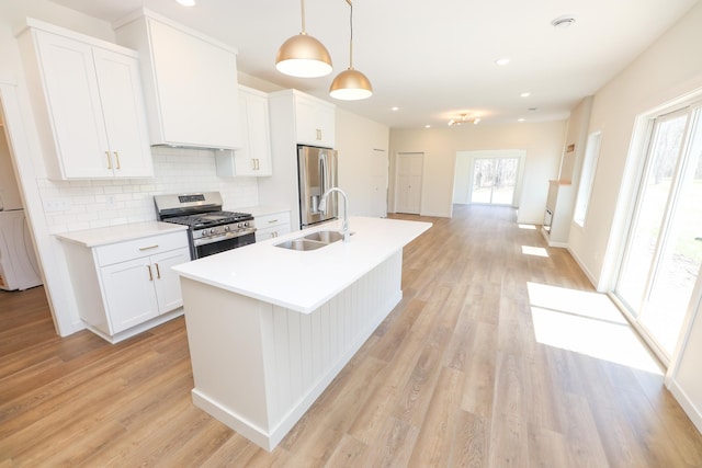 kitchen featuring a wealth of natural light, stainless steel appliances, light wood-style flooring, and a sink