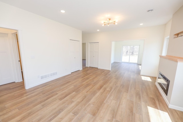unfurnished living room featuring baseboards, visible vents, light wood-style floors, and recessed lighting