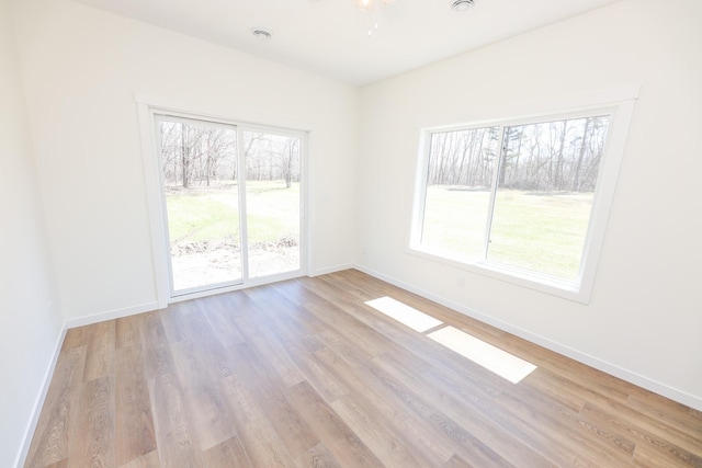 spare room featuring baseboards and wood finished floors