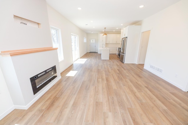 unfurnished living room featuring recessed lighting, visible vents, baseboards, and light wood-style floors