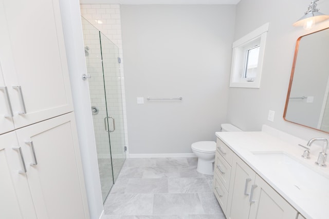 bathroom featuring toilet, vanity, a shower stall, and baseboards