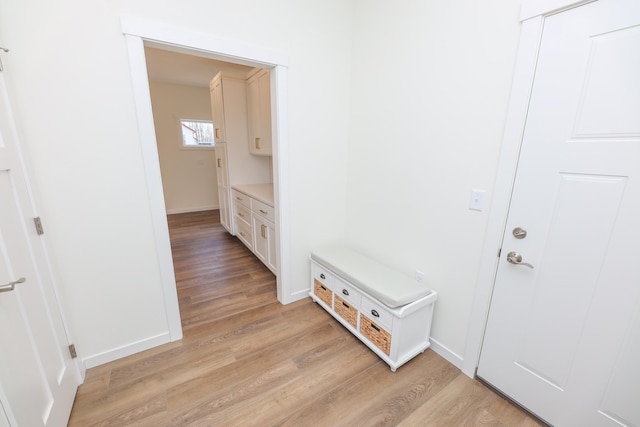 mudroom featuring baseboards and light wood finished floors