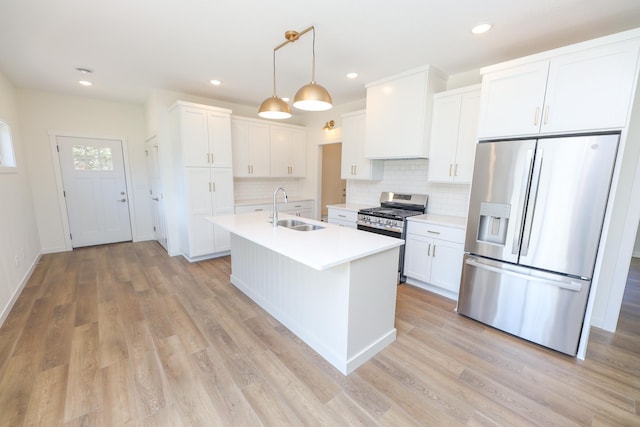 kitchen with decorative backsplash, white cabinets, a sink, appliances with stainless steel finishes, and light countertops