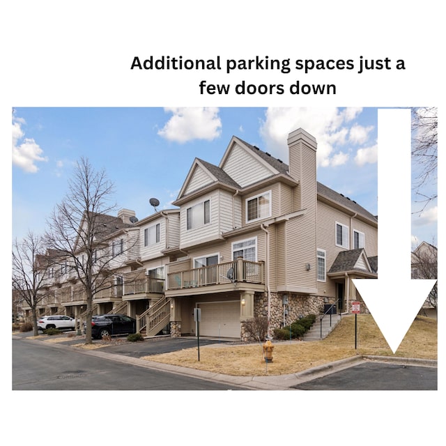 exterior space with an attached garage, driveway, and stairway