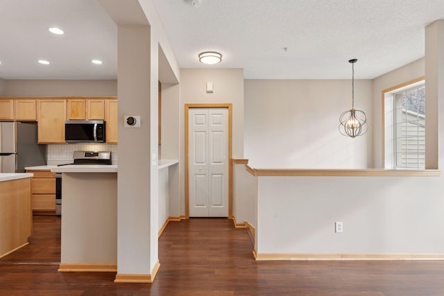 kitchen with light brown cabinets, stainless steel appliances, dark wood-style flooring, light countertops, and backsplash