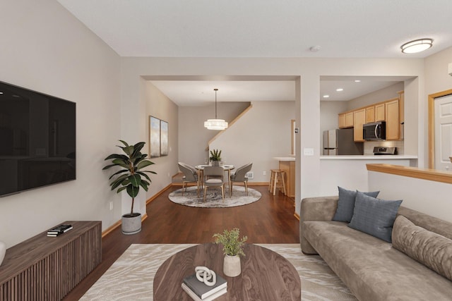 living area featuring baseboards, wood finished floors, and recessed lighting