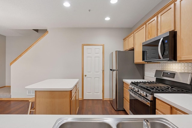 kitchen with light brown cabinets, stainless steel appliances, decorative backsplash, and light countertops