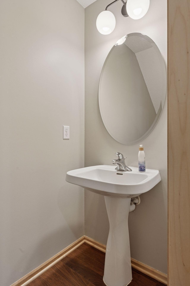 bathroom featuring a sink, baseboards, and wood finished floors