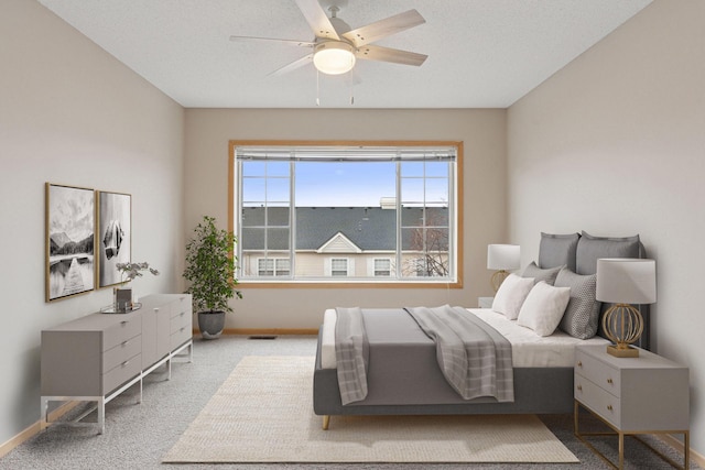 carpeted bedroom with visible vents, ceiling fan, and baseboards