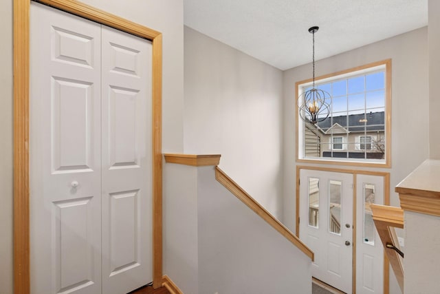 entrance foyer featuring a textured ceiling and an inviting chandelier