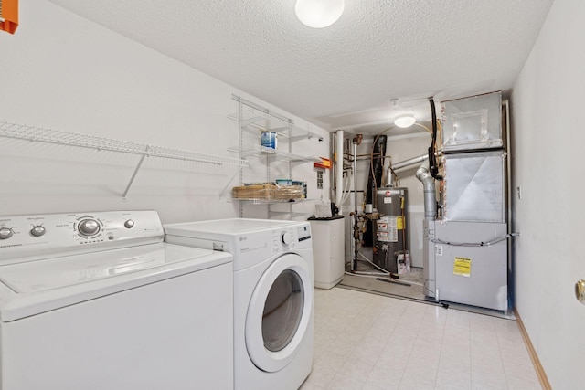 washroom featuring gas water heater, light floors, a textured ceiling, laundry area, and independent washer and dryer