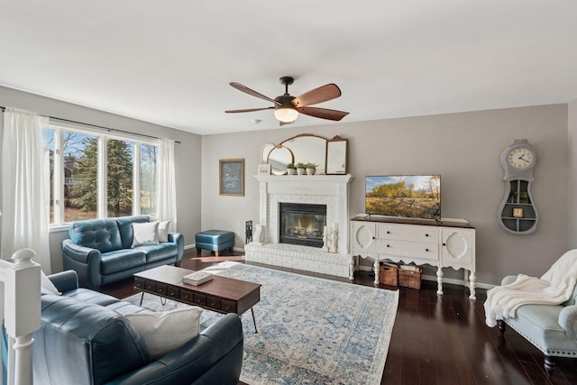 living room with hardwood / wood-style flooring, a fireplace, baseboards, and ceiling fan