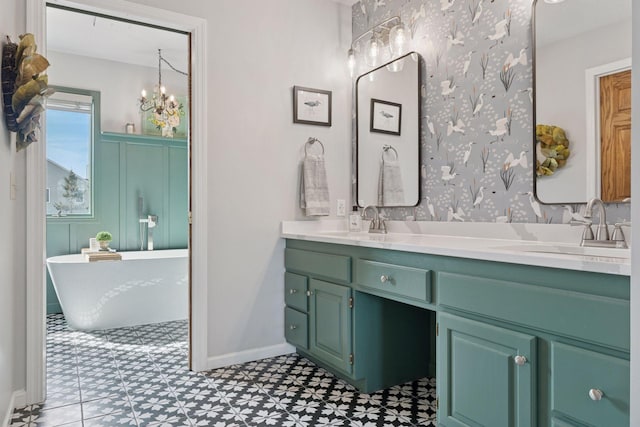 bathroom featuring a sink, a freestanding tub, double vanity, and tile patterned floors