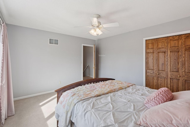 bedroom featuring baseboards, visible vents, ceiling fan, a closet, and light carpet