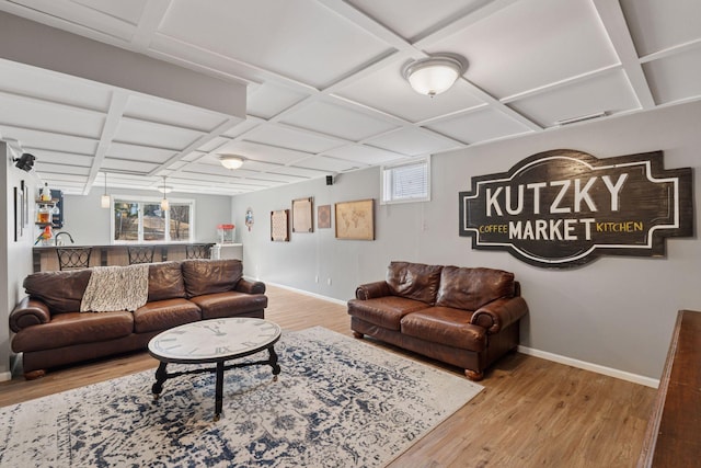 living area featuring baseboards, coffered ceiling, and wood finished floors