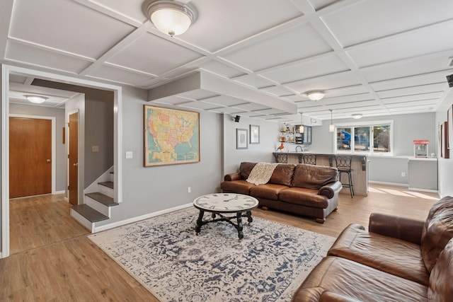 living room with light wood-style flooring, coffered ceiling, stairs, and baseboards