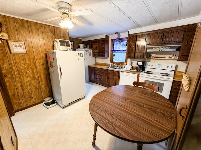 18863 State Highway 65, Goodland Twp, MN 55742 - kitchen featuring white appliances, wooden walls, light floors, under cabinet range hood, and a sink