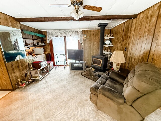 18863 State Highway 65, Goodland Twp, MN 55742 - living room featuring a wood stove, wood walls, beam ceiling, and ceiling fan