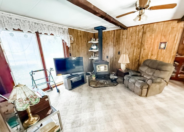18863 State Highway 65, Goodland Twp, MN 55742 - living area with a wood stove, wooden walls, a ceiling fan, and beam ceiling