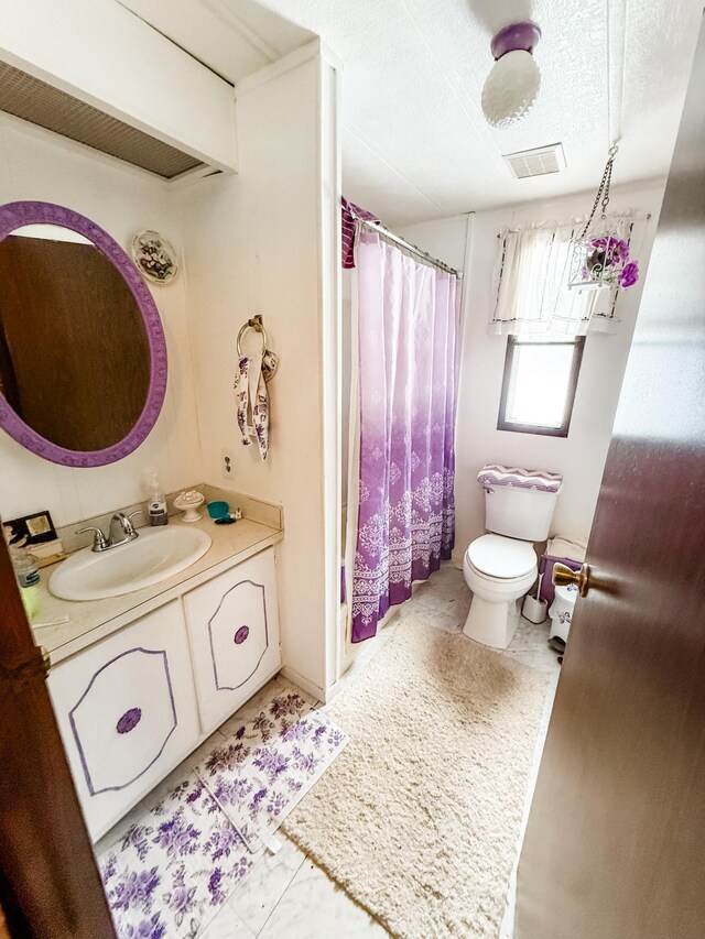 18863 State Highway 65, Goodland Twp, MN 55742 - full bath with visible vents, toilet, tile patterned floors, a textured ceiling, and vanity