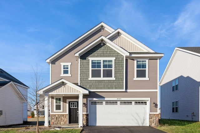 craftsman house featuring board and batten siding, stone siding, driveway, and an attached garage