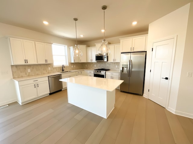 kitchen featuring decorative backsplash, appliances with stainless steel finishes, white cabinetry, and a sink