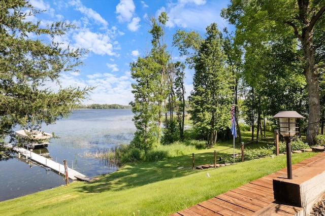 view of dock featuring a water view and a yard