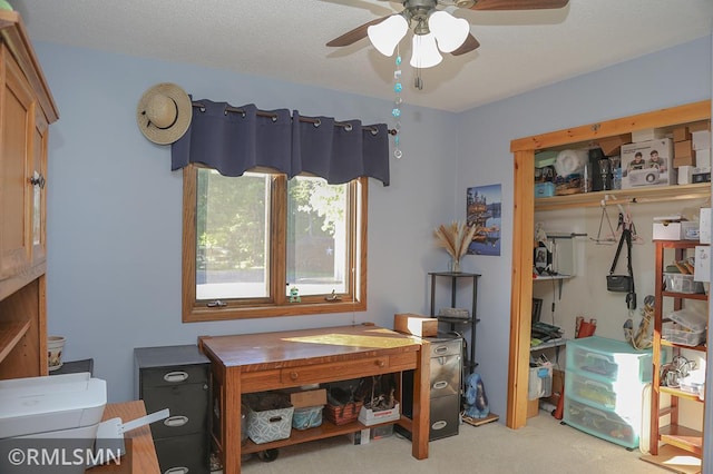 carpeted office featuring a textured ceiling and ceiling fan