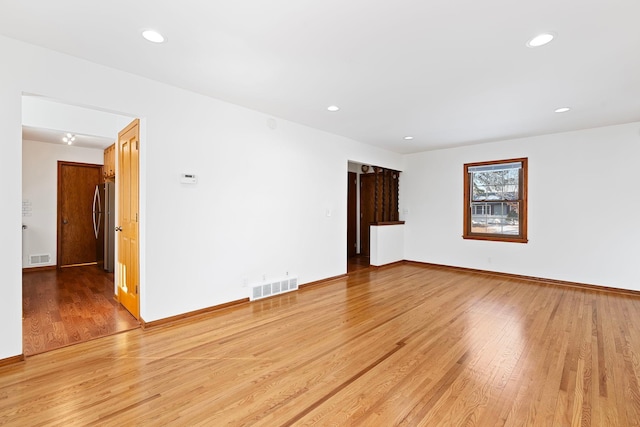 spare room with light wood-type flooring, visible vents, and recessed lighting