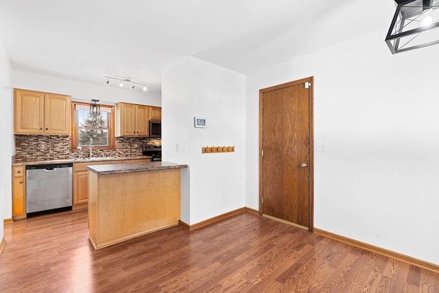 kitchen featuring dark wood-style floors, stainless steel appliances, dark countertops, backsplash, and a sink