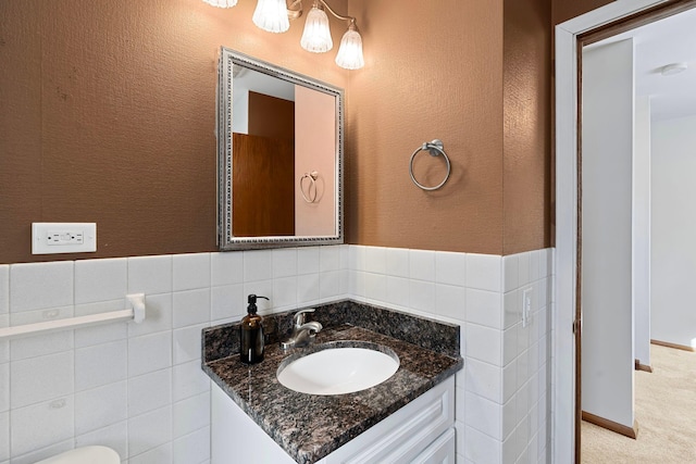 bathroom featuring a textured wall, tile walls, and vanity