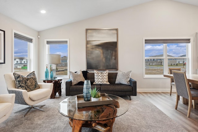 living area featuring light wood-style floors, vaulted ceiling, a wealth of natural light, and recessed lighting