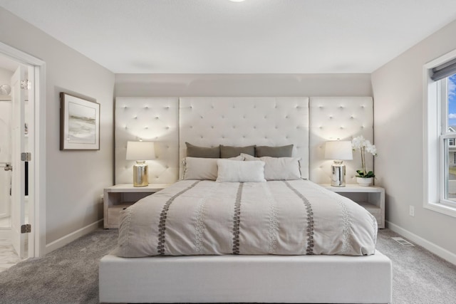 bedroom featuring light carpet, ensuite bath, visible vents, and baseboards