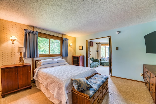 bedroom featuring wallpapered walls, baseboards, a textured ceiling, and light colored carpet