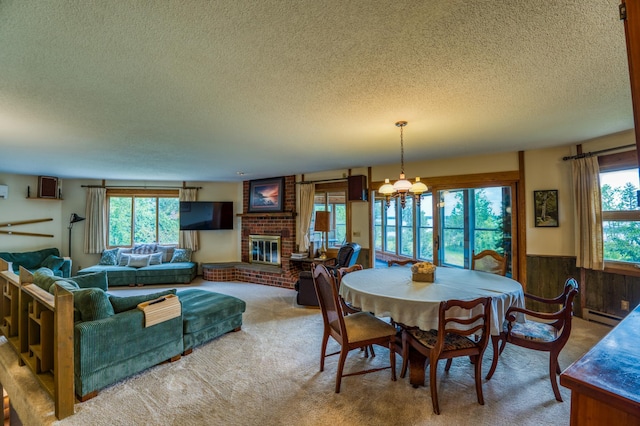 carpeted dining area featuring a wainscoted wall, a fireplace, a wealth of natural light, and a textured ceiling