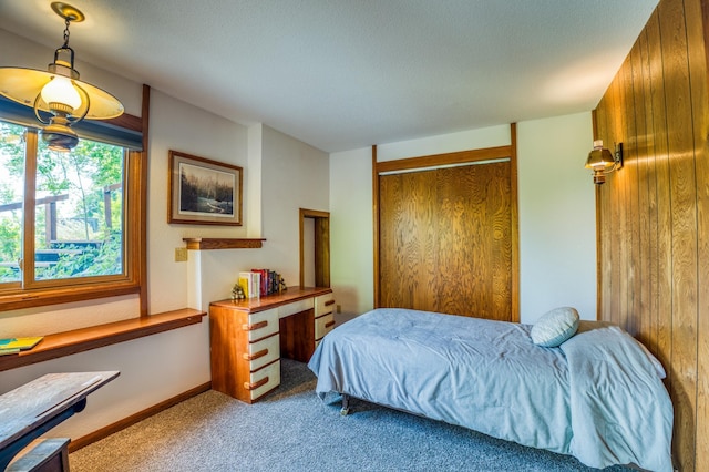 bedroom featuring baseboards, a closet, and light colored carpet