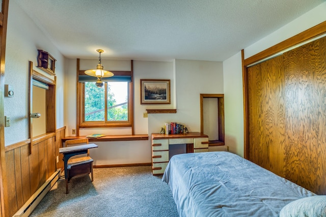 carpeted bedroom featuring a textured ceiling and a baseboard radiator