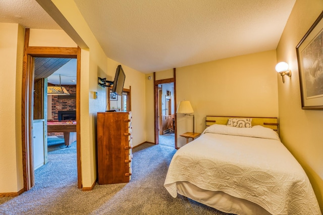 bedroom featuring carpet, a brick fireplace, a textured ceiling, and baseboards