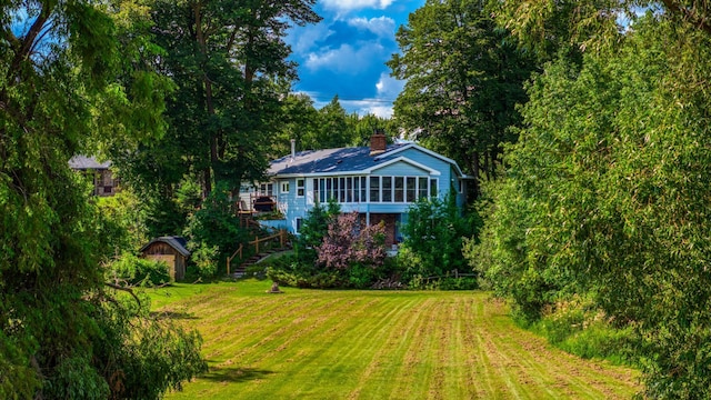 view of yard featuring a storage shed, stairway, an outbuilding, and a sunroom