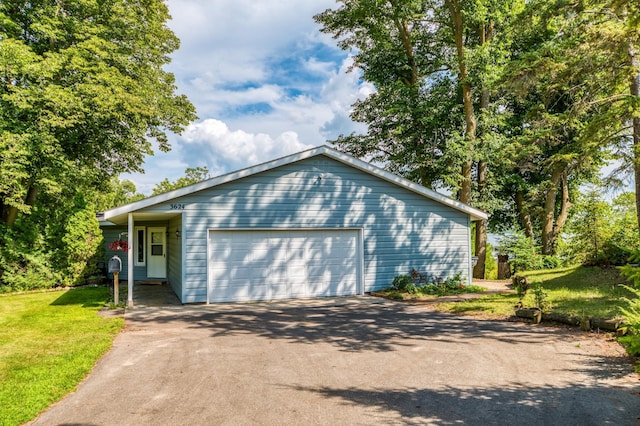 view of front of house featuring a garage, driveway, and a front lawn