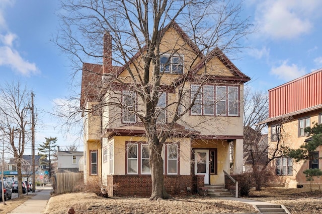 view of front of property featuring brick siding and stucco siding