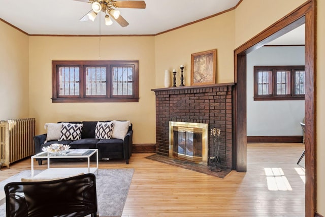 living area featuring ornamental molding, radiator heating unit, wood finished floors, and baseboards