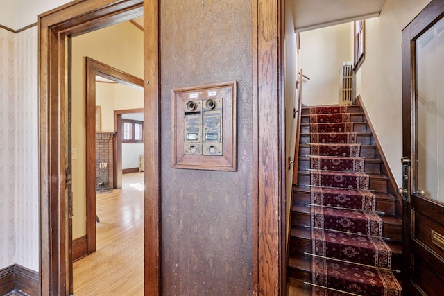 staircase featuring baseboards and wood finished floors