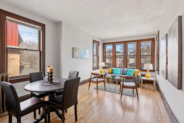 dining space featuring light wood-style flooring and baseboards