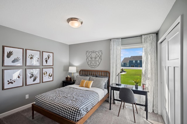 carpeted bedroom with a closet and baseboards