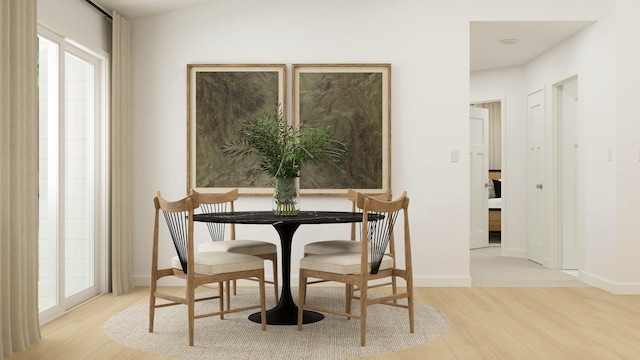 dining room featuring light wood-style flooring and baseboards