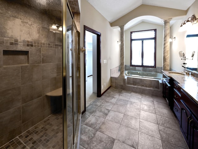 full bath featuring double vanity, a stall shower, decorative columns, lofted ceiling, and a sink