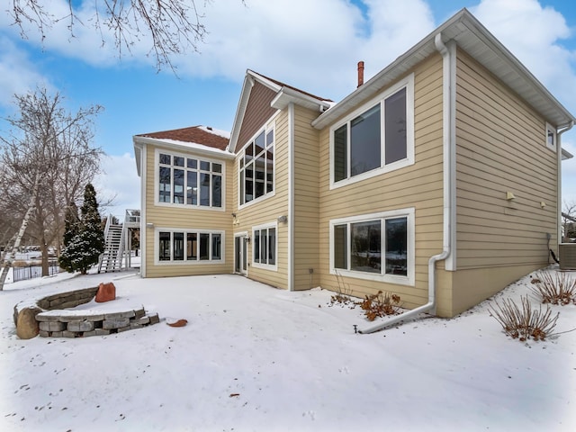 snow covered property with a chimney